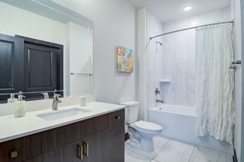 a bathroom with a toilet sink and shower and a mirror